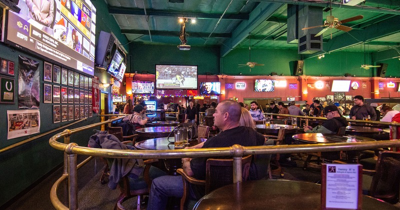 Interior, seating area with guests, tv sets on the walls