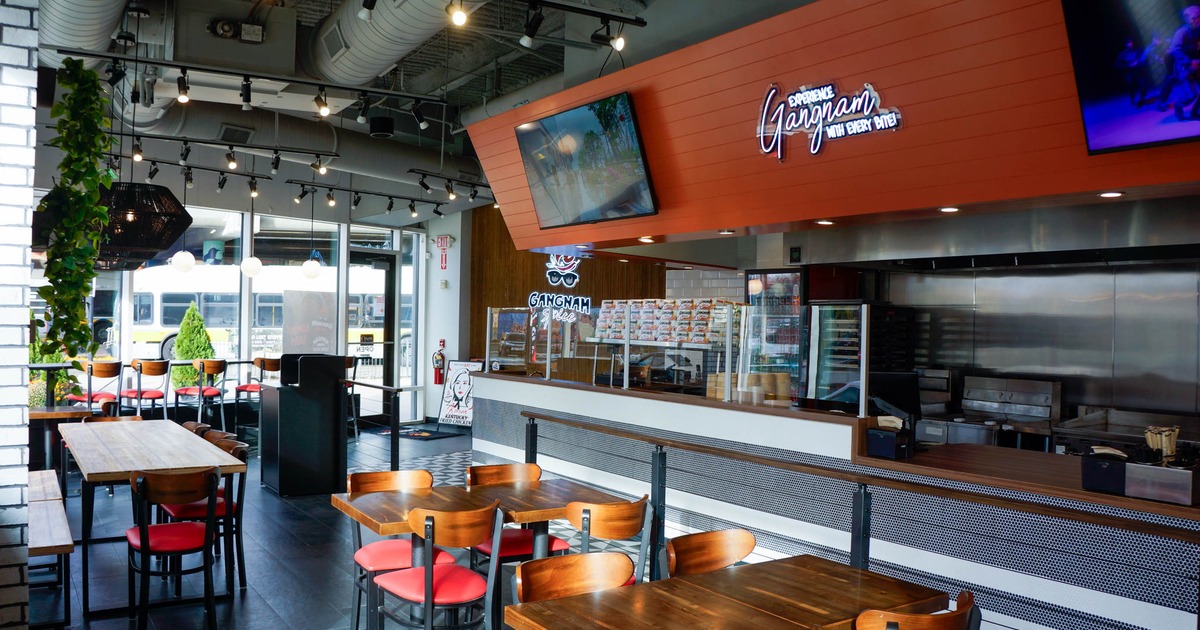 Interior, dining area, wooden top tables with chairs, counter and kitchen on the right