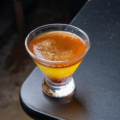 Amber-colored cocktail in a stemless martini glass.