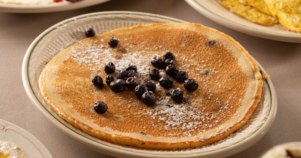 Pancake topped with blueberries and powdered sugar