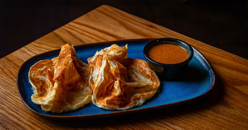 Roti Canai Malaysian flat bread, served with spicy coconut kari gravy