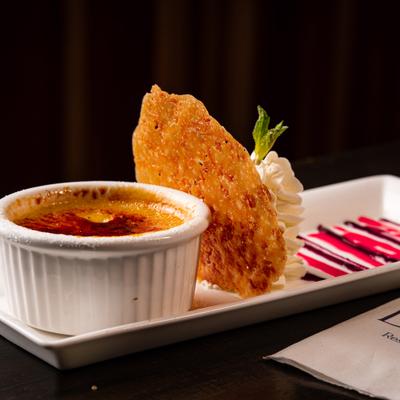 Creme Brulee with a fritter and whipped cream.