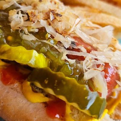 An extreme close up of All American Hot Dog paired with french fries.