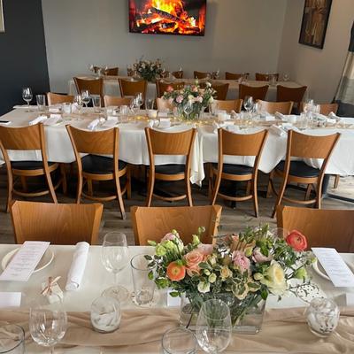 Dining table setup with flower arrangements, plates, napkins and glassware.