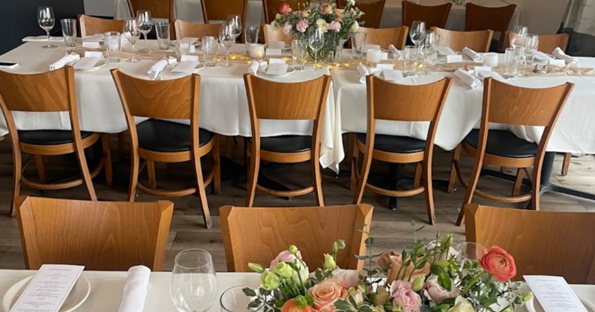 Dining table setup with flower arrangements, plates and glassware