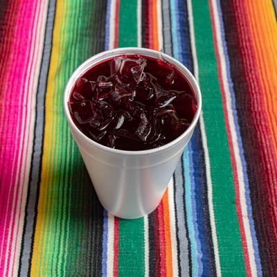 A white cup of Horchata drink served on a table with traditional blanket.