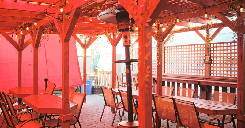 Covered patio with empty chairs and tables waiting for guests