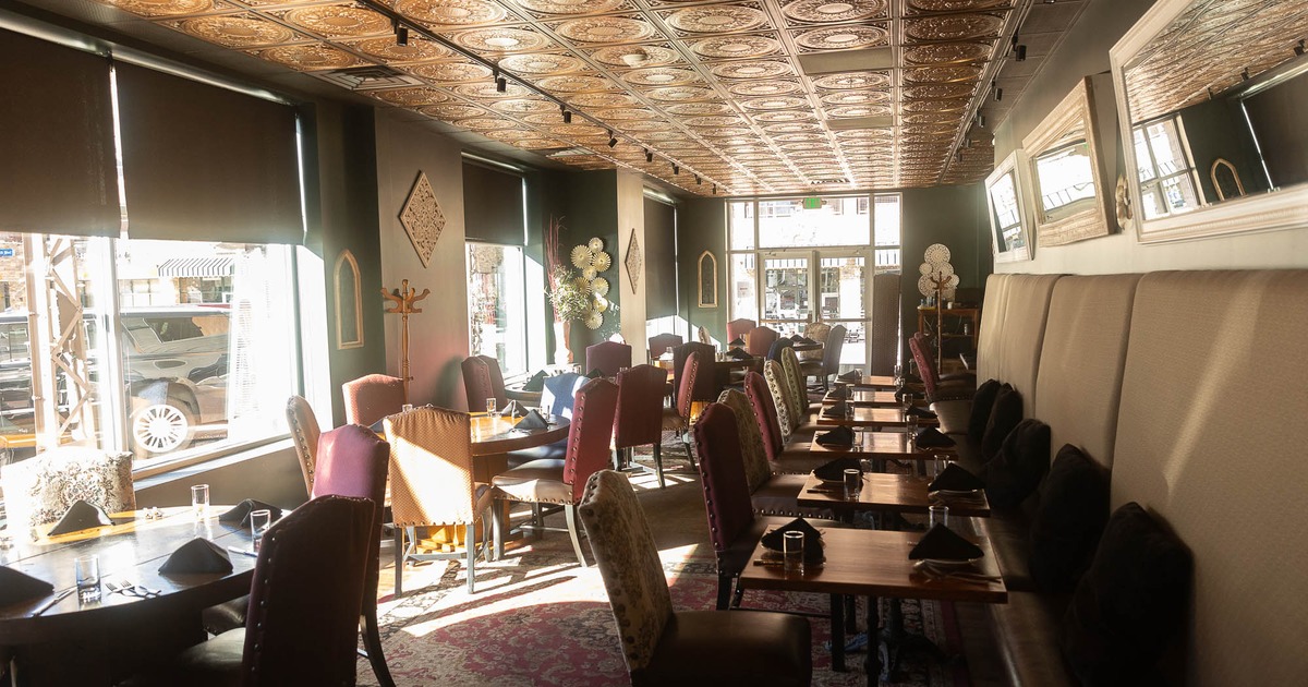 Interior, banquet seating on the left, tables with chairs on the right