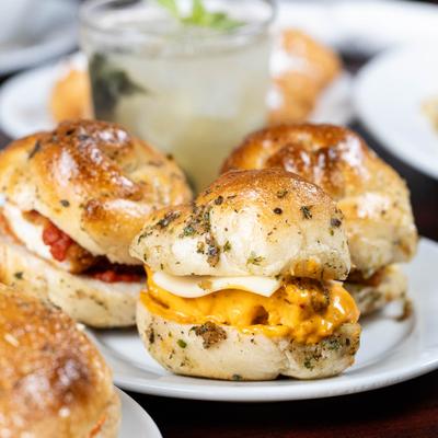 Plate of Garlic Knot Sliders served alongside a cocktail.