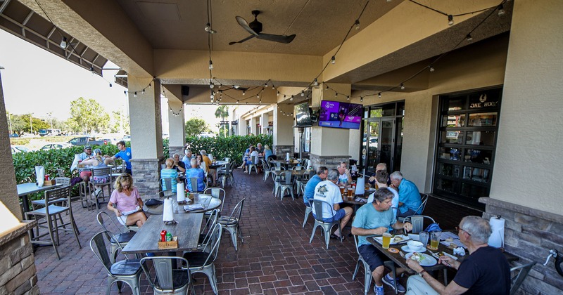 Exterior, roof-covered patio with guests enjoying their meals