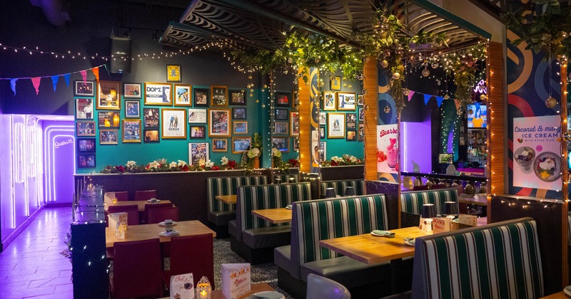 Interior, wide view of dining area, tables with chairs and booth area
