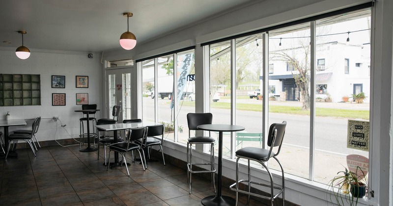 Interior, bar stools and tables, large shop window on the right
