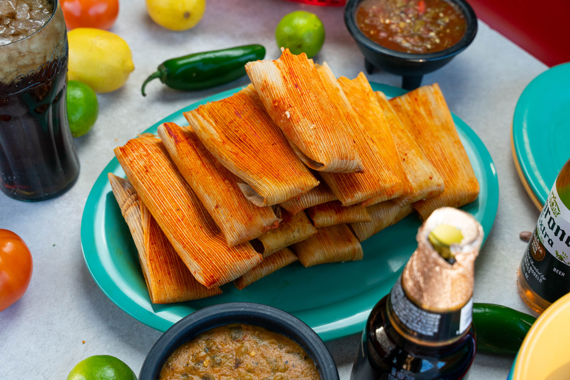 Red Pork Tamales Tower surrounded by food and drinks, top view