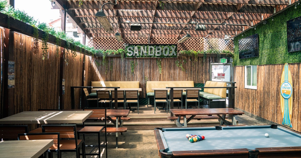 Outdoor patio with pool table, seating, and pergola