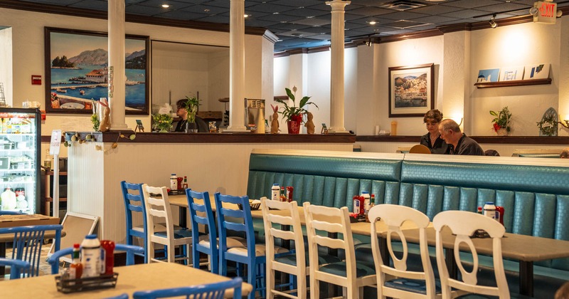 Interior, dining area, long padded banquette bench with tables and wooden chairs