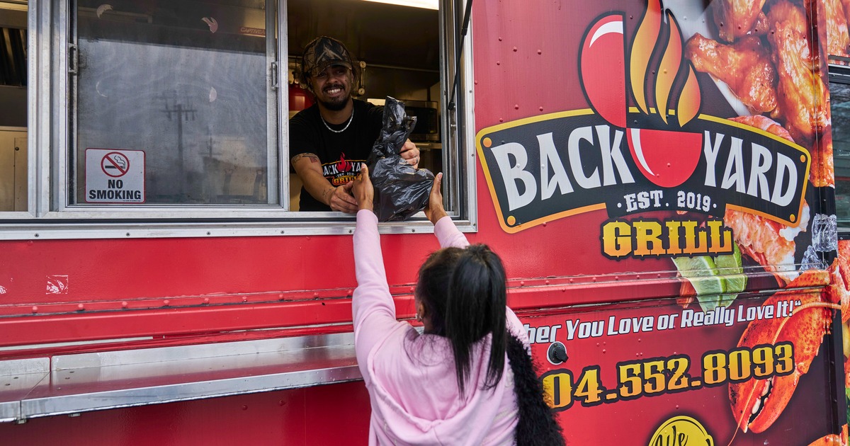 Person receiving food from a red food truck window