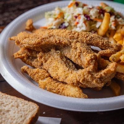 Fried catfish with sides of french fries and coleslaw.
