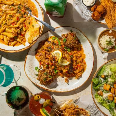 Table spread of various dishes and colorful drinks.