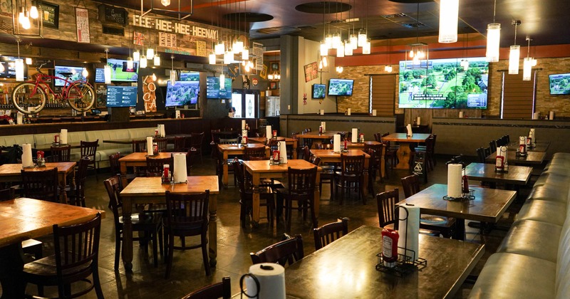 Interior of a casual dining restaurant featuring wooden tables and chairs, hanging lights