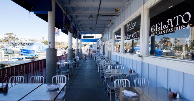 A row of tables and chairs lined up on the patio cover