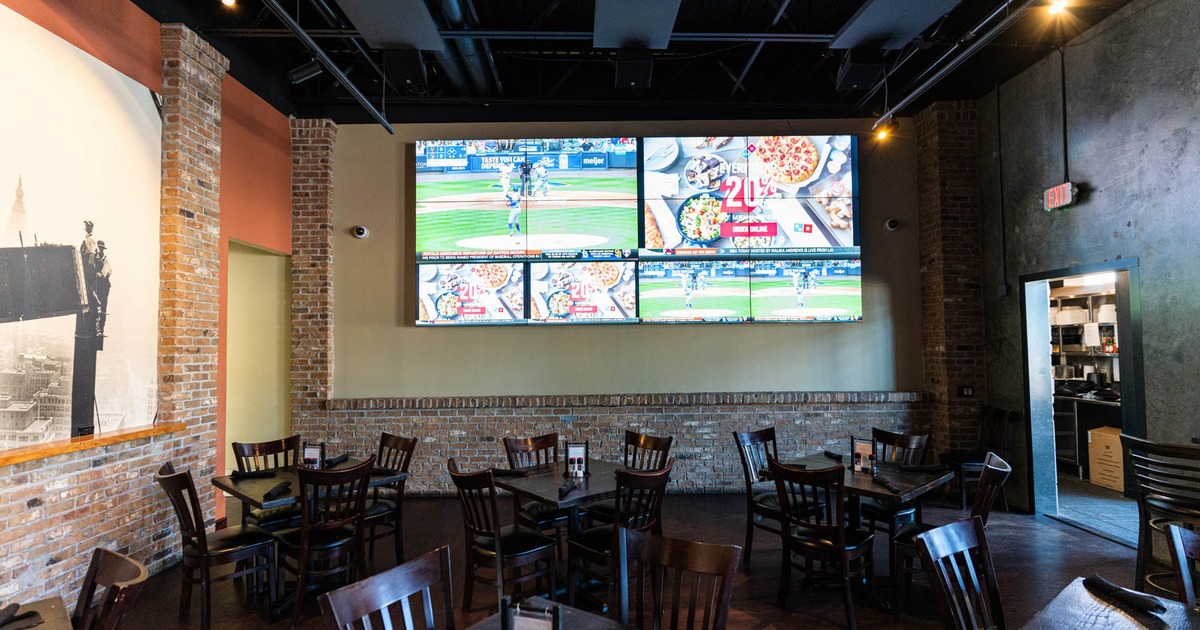 Interior, tables and seats, TV screens on a wall