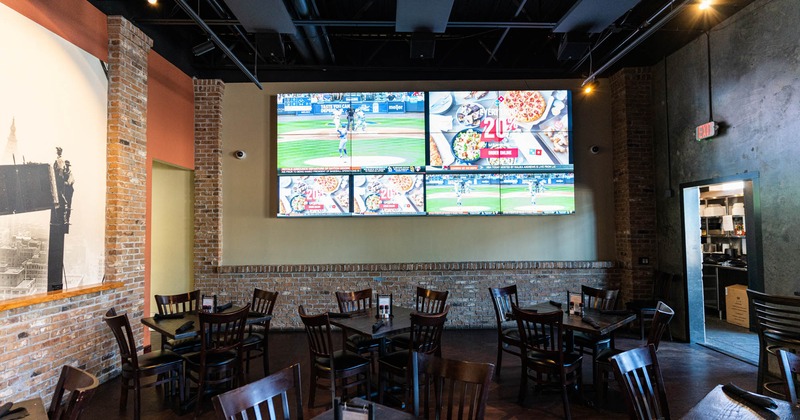 Interior, tables and seats, TV screens on a wall