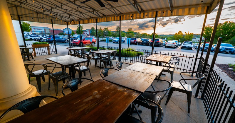 Outdoor seating area with wooden tables and metal chairs
