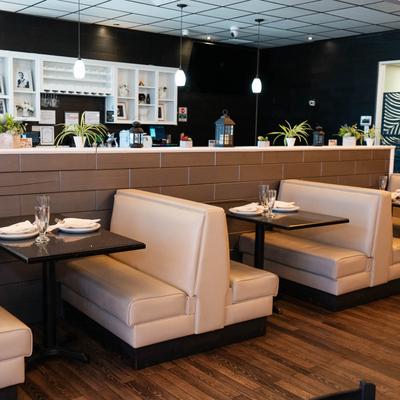 Interior, restaurant booths with tables set with tableware.