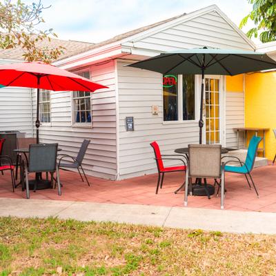 Outdoor patio seating with umbrellas beside the cafe building.