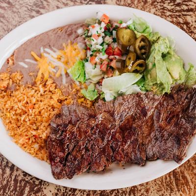 Grilled steak with rice, refried beans, pico de gallo,  and guacamole.