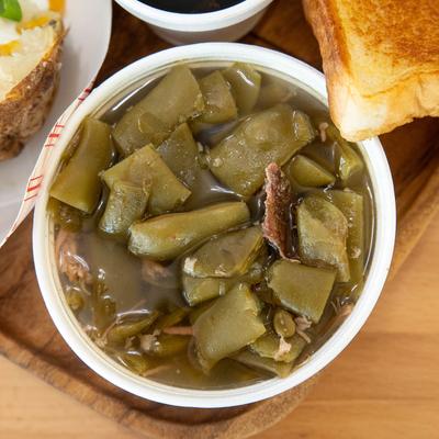 Close up of a side of green beans on a food platter.