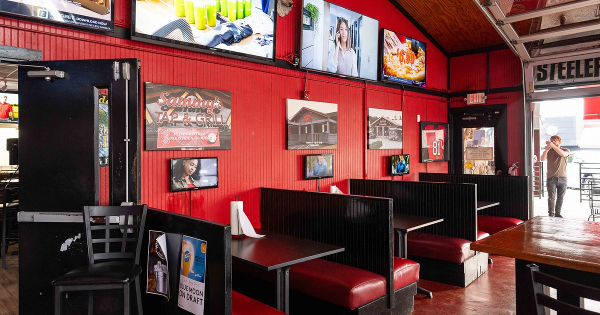 Interior, private booths all lined up ready for guests with pictures and TVs on the wall