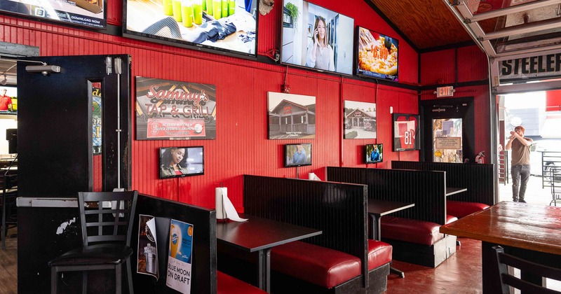 Interior, private booths all lined up ready for guests with pictures and TVs on the wall