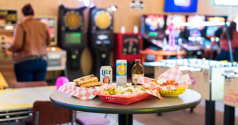 Hig-top table with various food items, caned and bottled drinks
