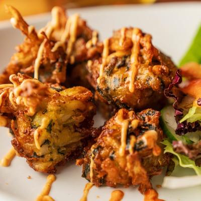Vegetable fritters in dynamite sauce.