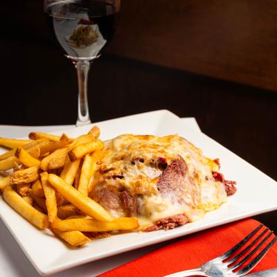 Reuben sandwich served with fries and red wine