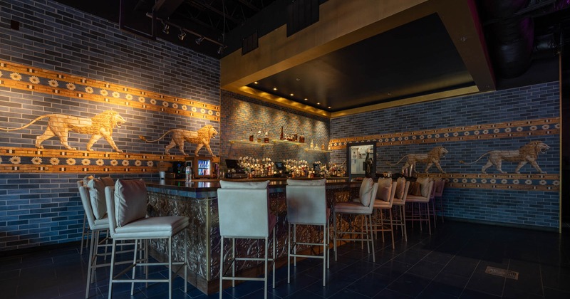A bar and walls decorated with a striding lion tiles, reminiscent of the Ishtar Gate decor