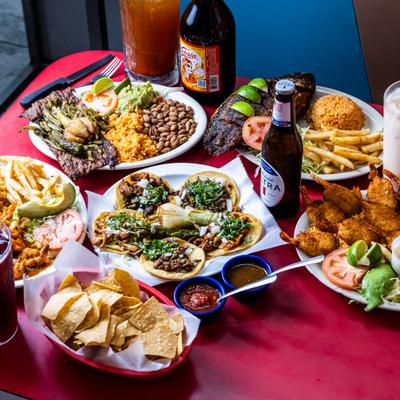 Assorted dishes and drinks arranged on a red table.