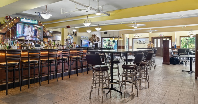 Interior, high tables and chairs near bar