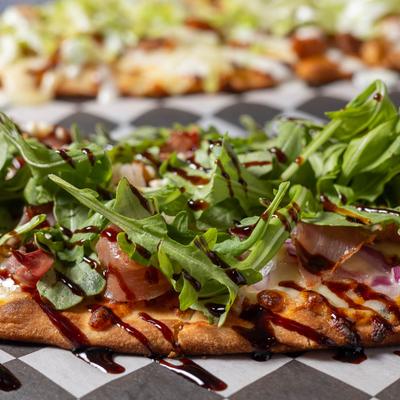Arugula and prosciutto flatbread, close up.