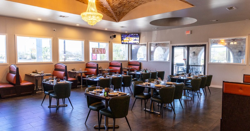 Interior view of a restaurant with tables, booths and a chandelier