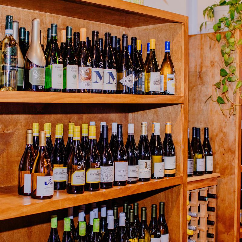 Wooden wine rack stocked with numerous bottles of wine.
