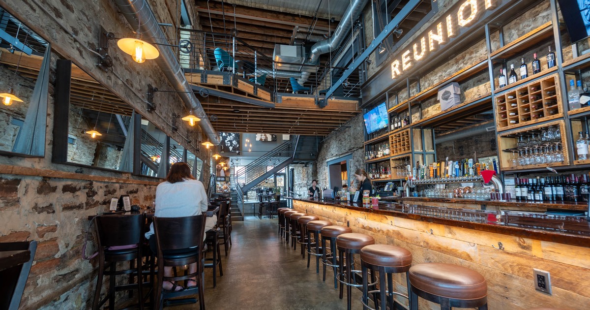 Interior, tables with bar stools on the left and bar on the right