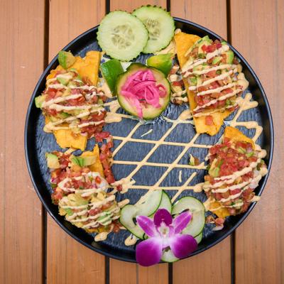 Tostones shrimp bites served with pickled red onions and cucumber slices.