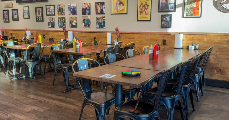 Interior, wooden tables with black metal chairs, condiment bottles, framed sports memorabilia