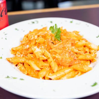 Penne alla Vodka garnished with fresh herbs.