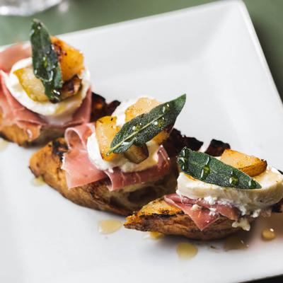 Grilled Tuscan Crostini, with cheese, poached pears, prosciutto and sage.