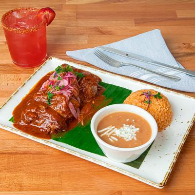 Beef smothered in birria sauce, served with rice and beans.