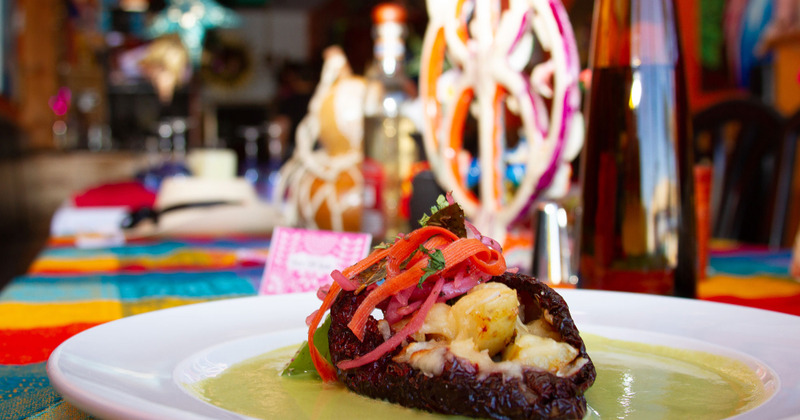 Filled chili pepper dish plate on a colorful tablecloth