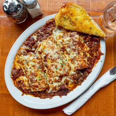 Stuffed cannelloni pasta, smothered in meat and cheese sauces.